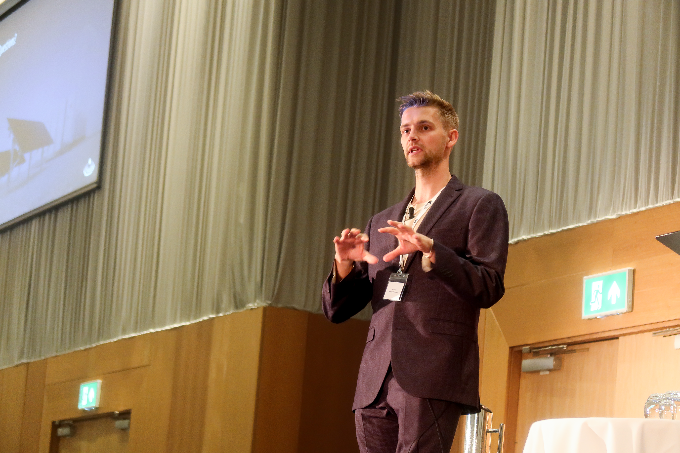 Low angle of young white man standing on stage presenting