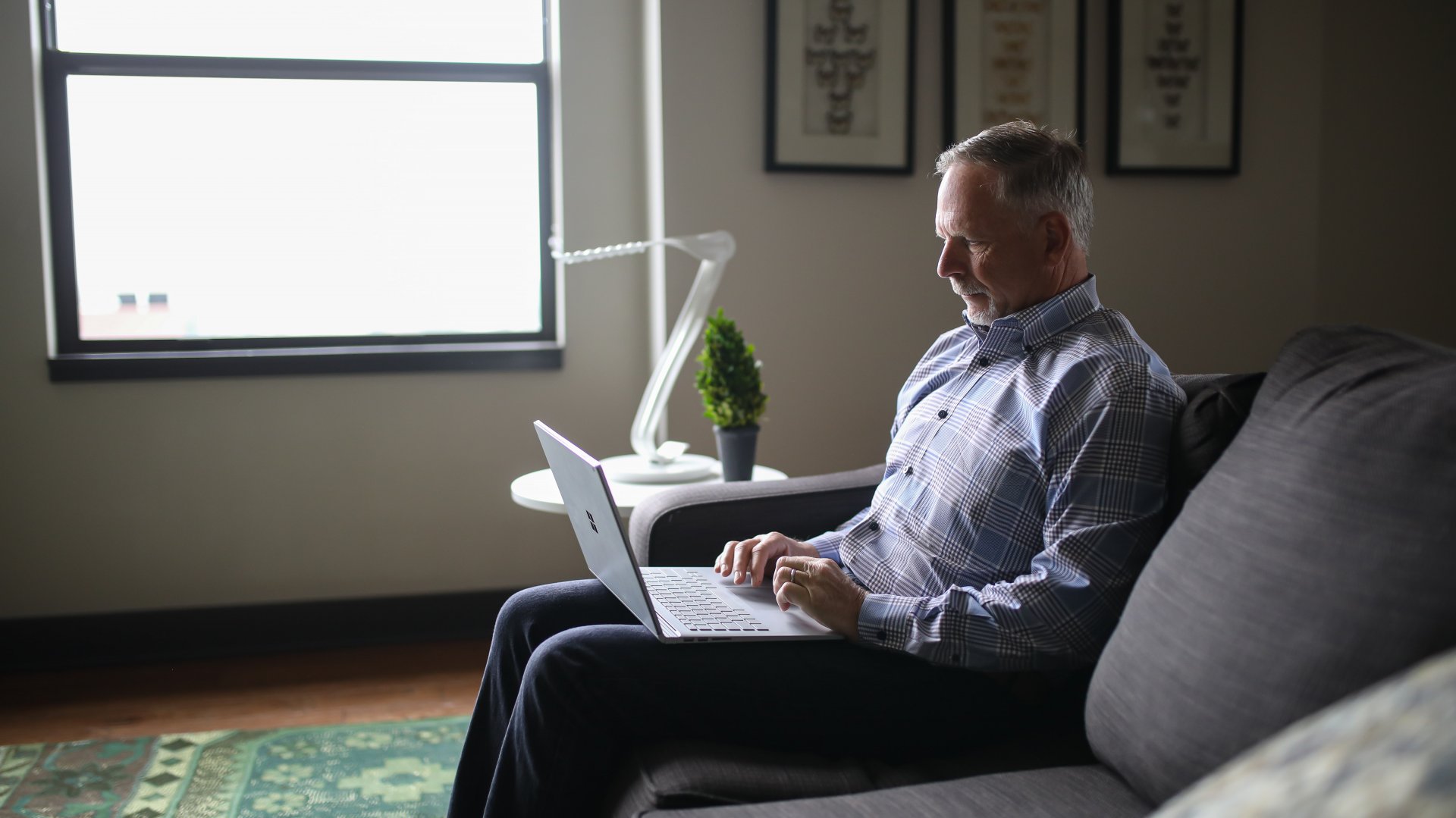 Older man using a laptop from his home