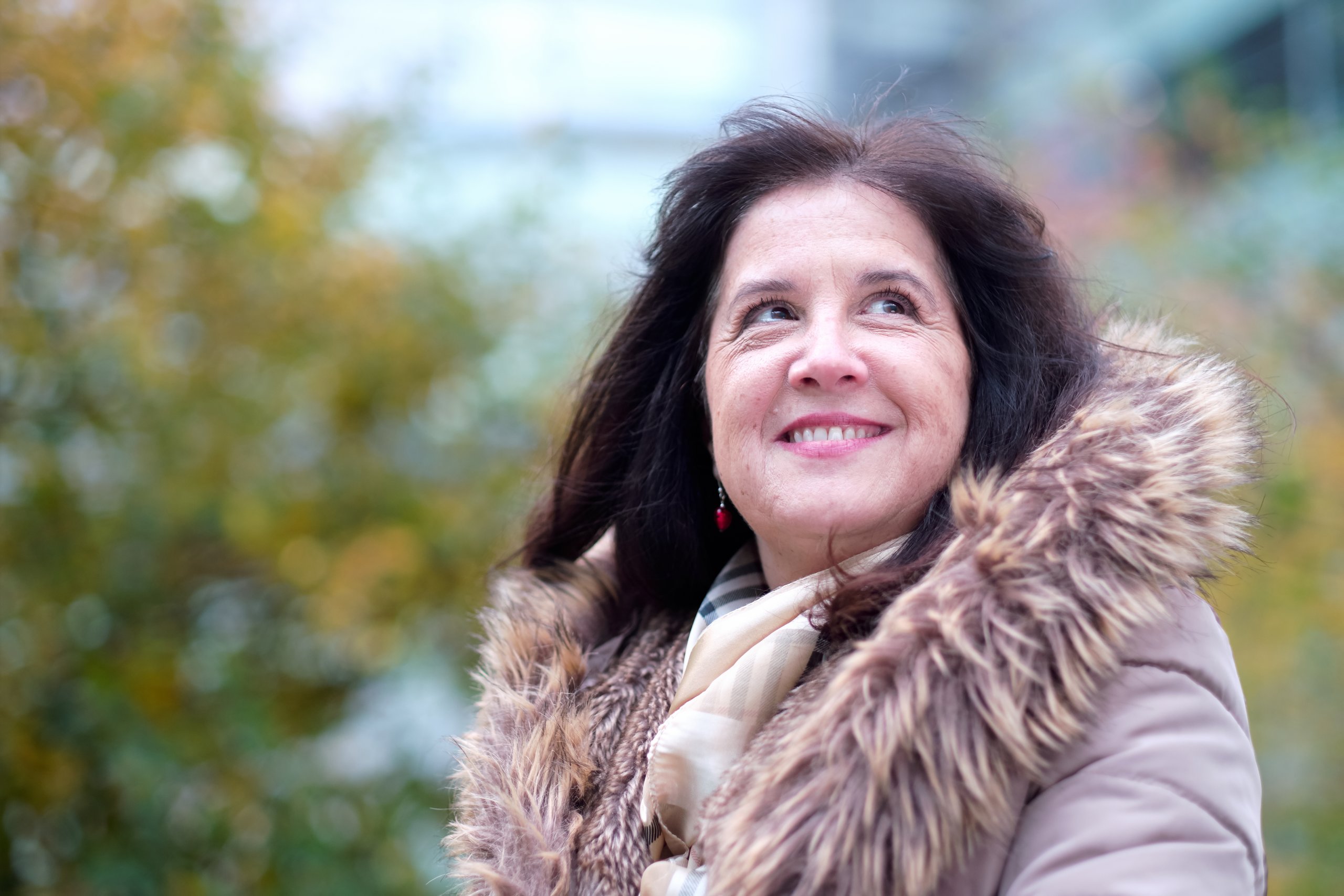 Prof. Lydia Tabernero sits outside in fur-hooded coat, smiling 