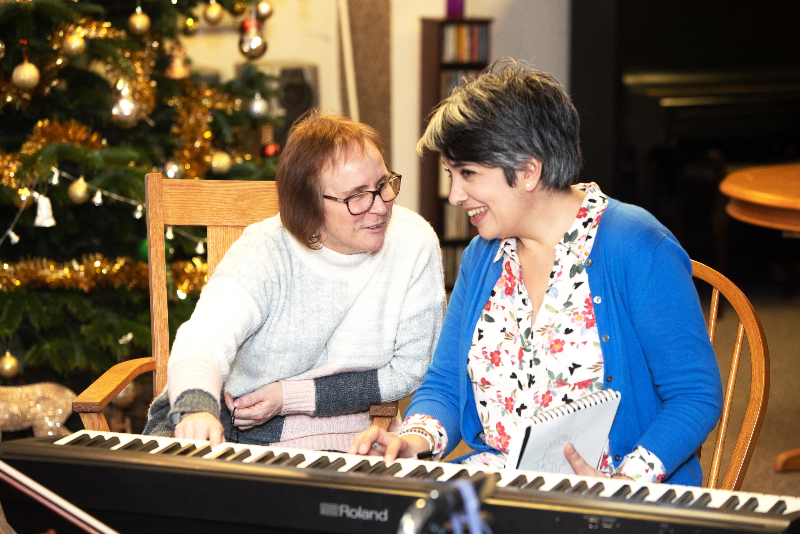 Women playing piano during music therapy.