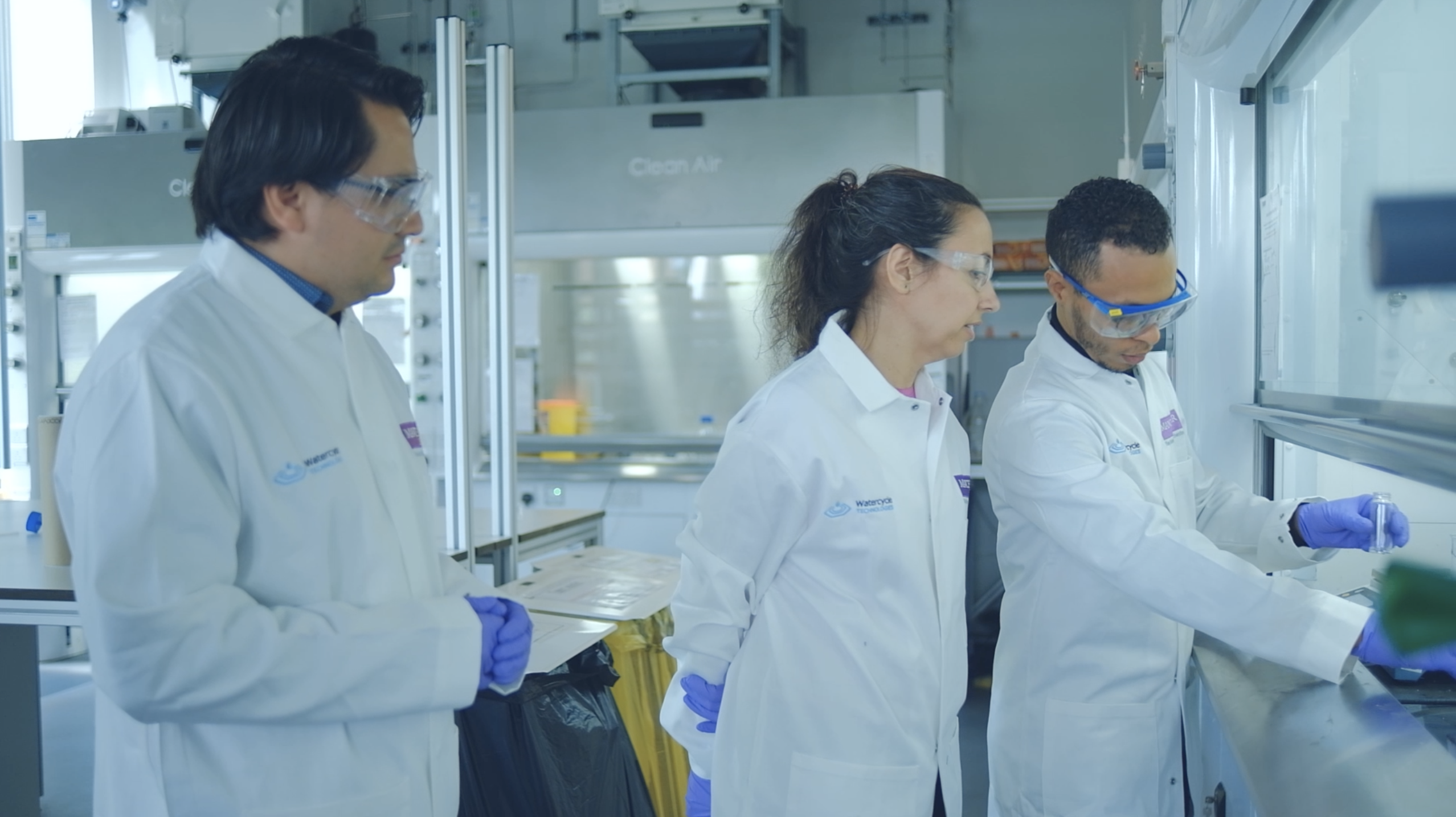 3 people in lab coats in high tech laboratory