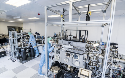 wide angle shot of a vacuum system with people wearing full PPE using it