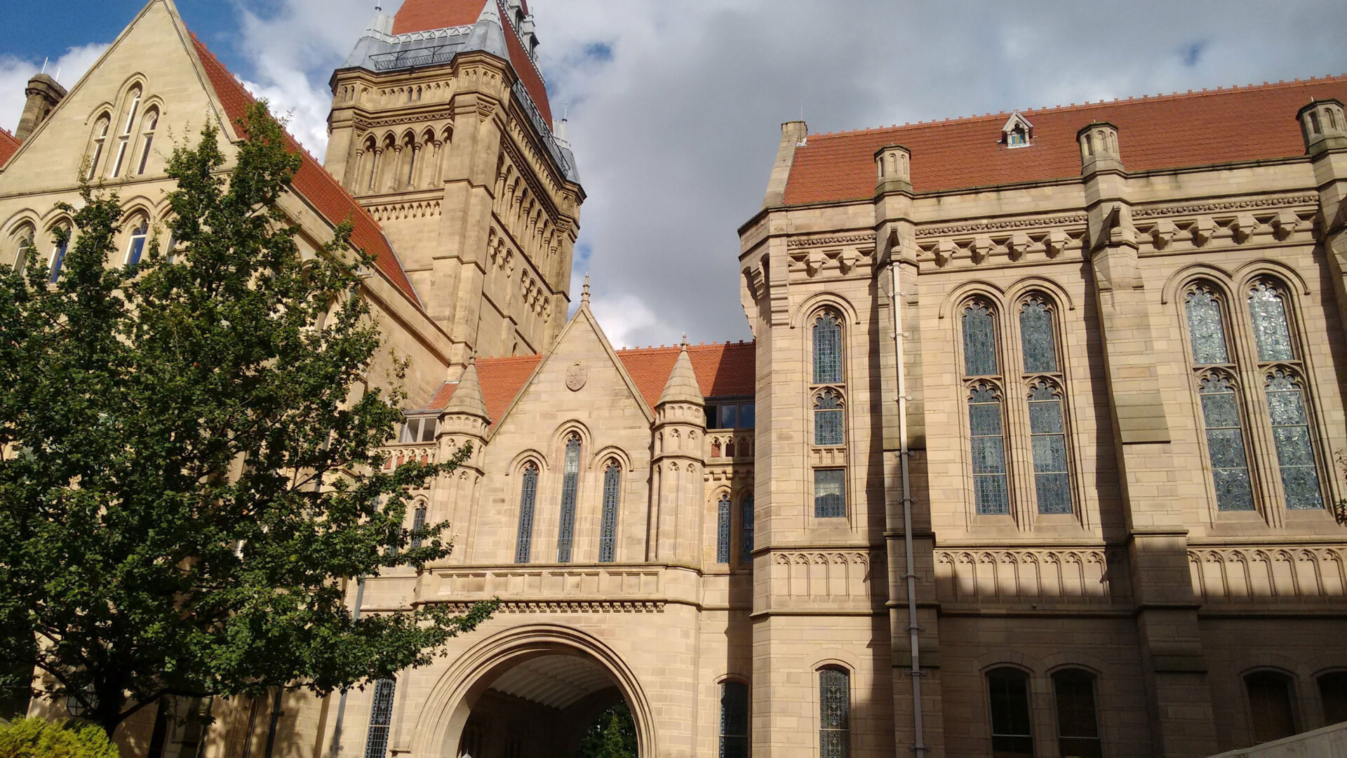 photo showing University of Manchester building with a tree in the foreground