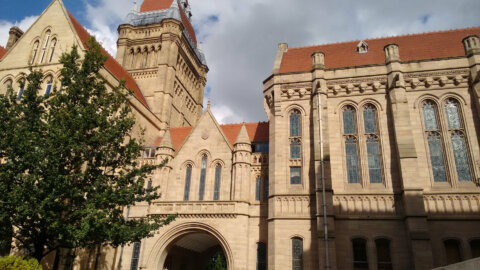 photo showing University of Manchester building with a tree in the foreground