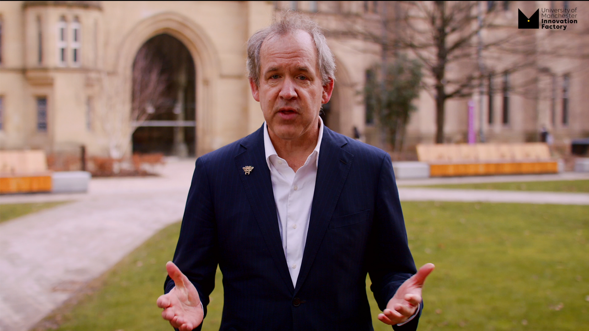 image of a man standing in a suit talking to the camera